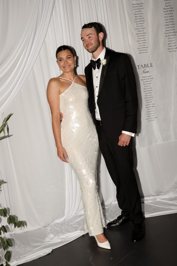 Bride and groom posing at their Jimbour House wedding reception in Queensland, with the bride wearing a modern white sequin reception dress and the groom in a classic black tuxedo.